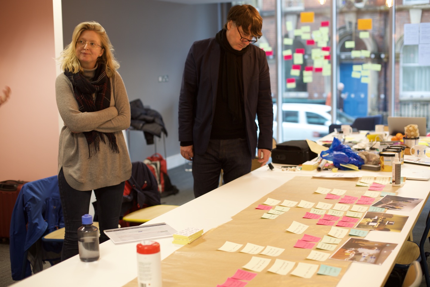 Two workshop participants look at a journey map made of post its.